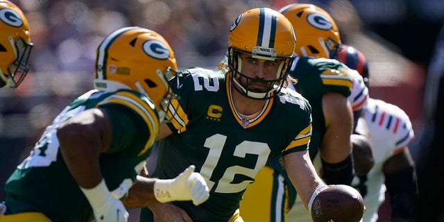 Green Bay Packers quarterback Aaron Rodgers (12) hands the ball back to AJ Dillon during the first half of an NFL football game Sunday, October 17, 2021 in Chicago.