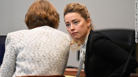 Amber Heard speaks to her attorney in Fairfax County Courthouse on Tuesday.