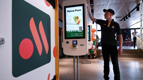 An employee cleans a self-ordering machine at the Russian version of a former McDonald's before an opening ceremony in Moscow.