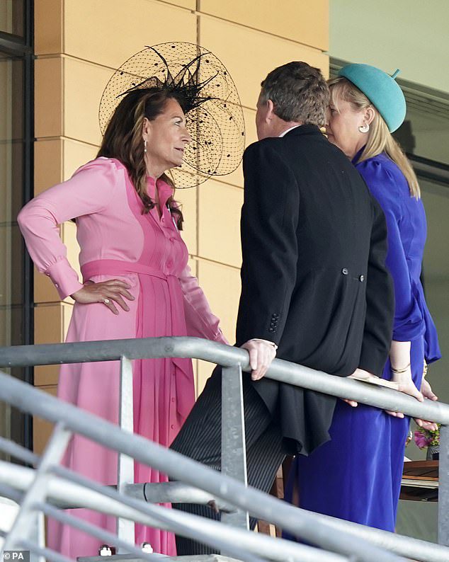 Carol teamed the dress with a black perforated hat with feather motifs.  She seemed to be enjoying her day outside chatting with fellow racing fans in the stands