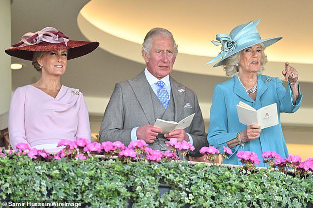 Meanwhile, Camilla pointed across the racetrack while posing alongside Prince Charles and sister-in-law Sophie Wessex.