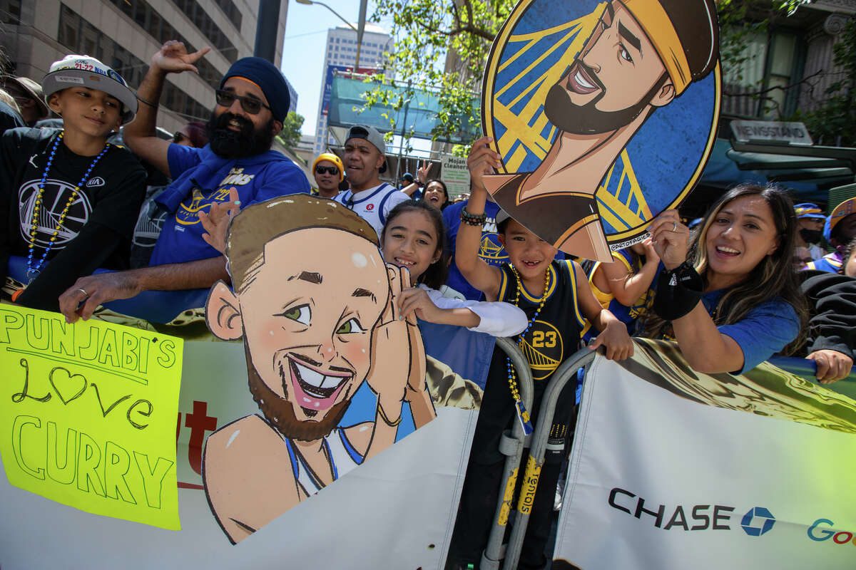 Warriors fans hold banners during the Golden State Warriors Championship Parade on Market Street in San Francisco, California on June 20, 2022.