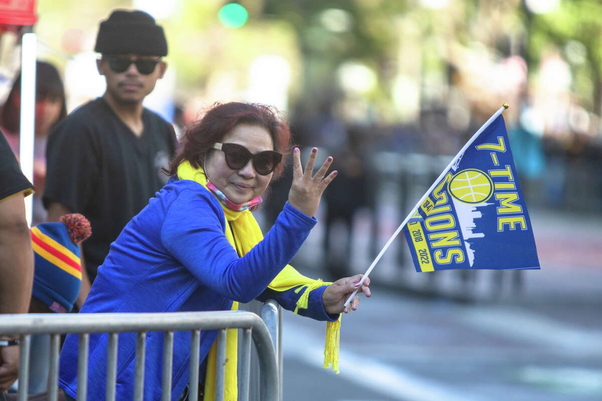 A woman holds the four fingers of the four Golden State Warriors ahead of the Golden State Warriors Championship Parade on Market Street in San Francisco, California on June 20, 2022.