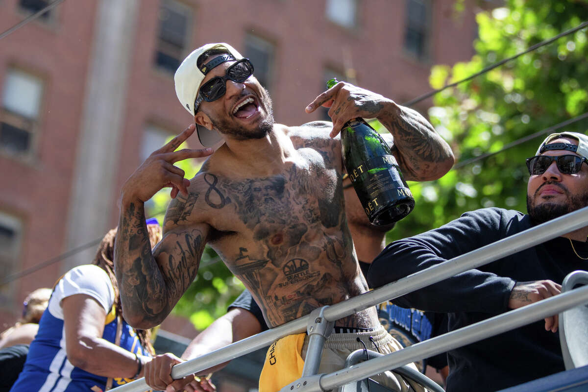 Forward Gary Payton II poses for a photo holding a bottle of Moet champagne during the Golden State Warriors Championship Parade on Market Street in San Francisco, California on June 20, 2022.