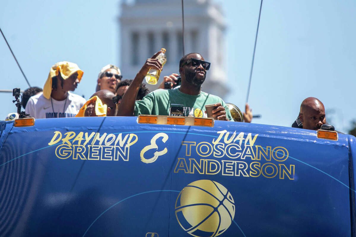 Golden State Warriors forward Draymond Green holds a bottle of Lobos Tequila during the Golden State Warriors Championship display on Market Street in San Francisco, California on June 20, 2022.