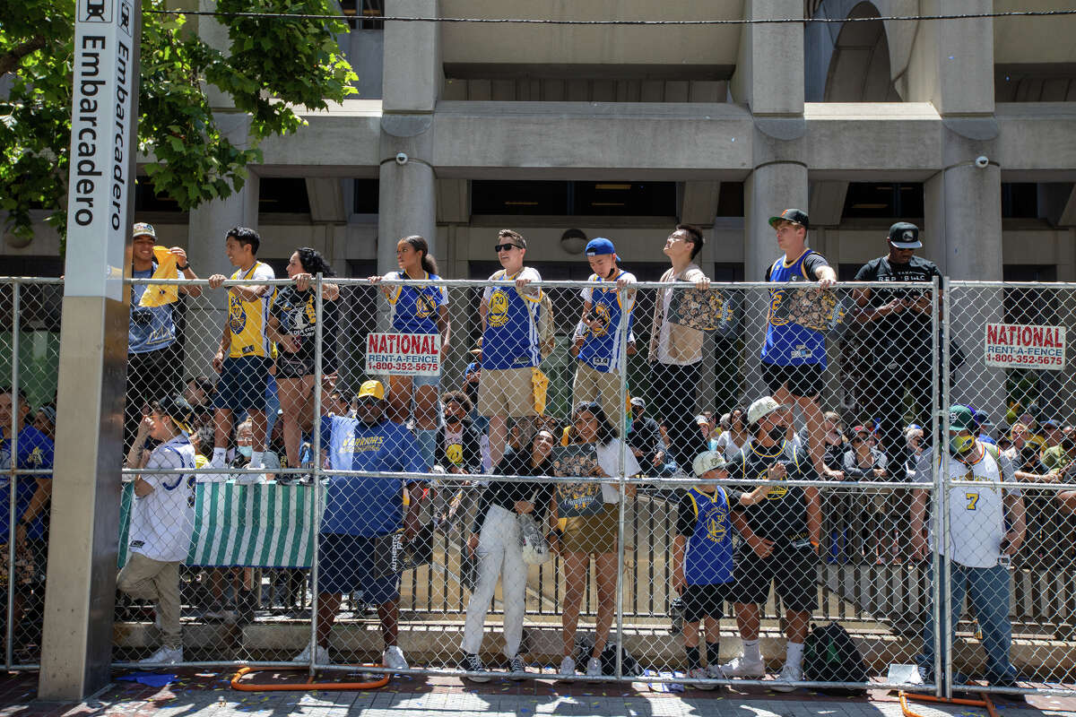Fans stand on a railroad track to watch the action during the Golden State Warriors Championship Parade on Market Street in San Francisco, California on June 20, 2022.
