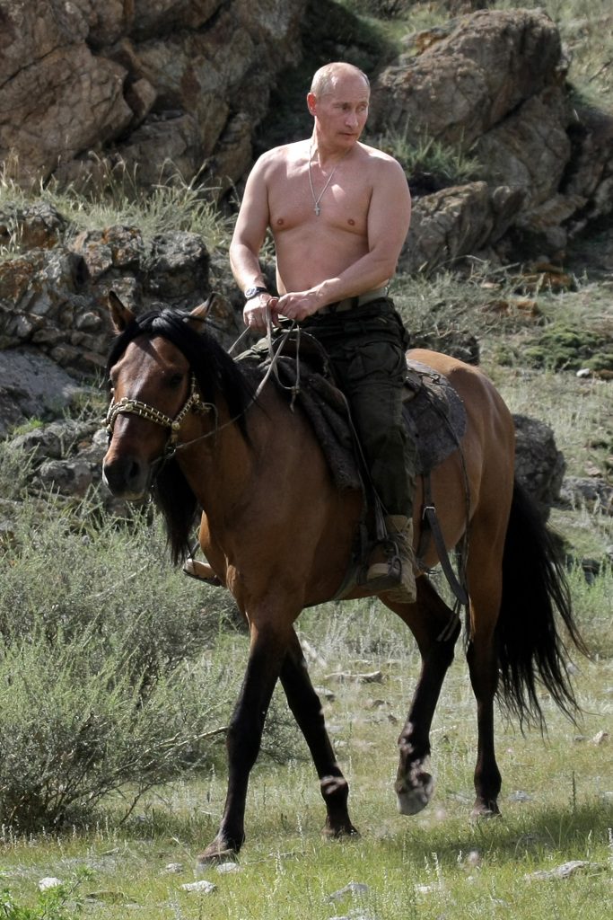 Russian President Vladimir Putin rides a horse without a shirt.