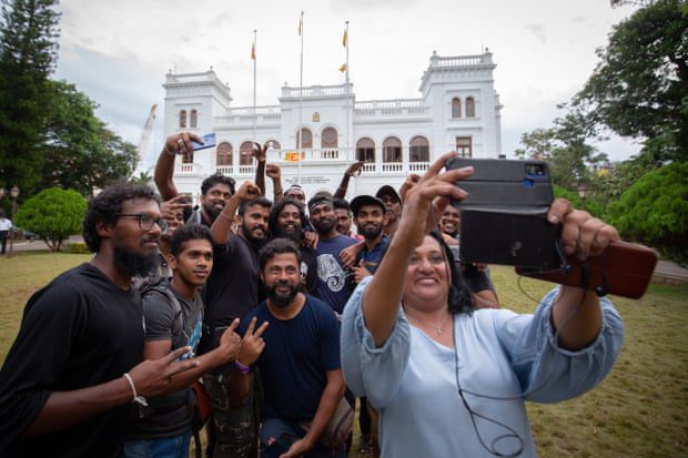 Protesters pose for a group selfie while returning the Prime Minister's office to government authorities