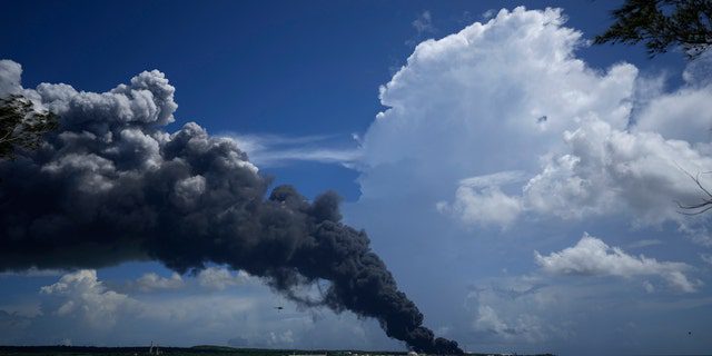 A huge plume of smoke rises from the base of the supertanker Matanzas, as firefighters work to put out a fire that broke out during a thunderstorm the night before, in Matazanas, Cuba, Saturday, August 6, 2022.