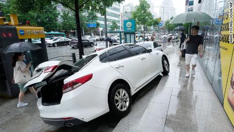 A vehicle sustained damage on the sidewalk after it got crunched in heavy rain in Seoul, South Korea on August 9.