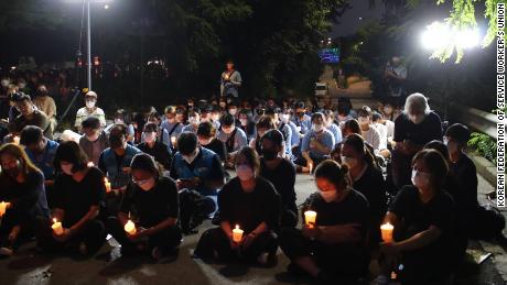 A small crowd holds a candlelight vigil in Seoul on August 11 to commemorate the death of a family after their home was flooded on August 8.
