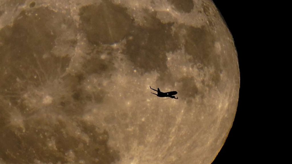 A plane passes in front of a full moon July 13, in Milwaukee. The moon's orbit brought it closer to Earth than usual. This cosmic combo is called a supermoon. A supermoon will occur again on Thursday night.