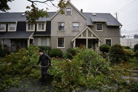 A man removes limbs and debris from his street in Halifax, Nova Scotia, on Saturday.