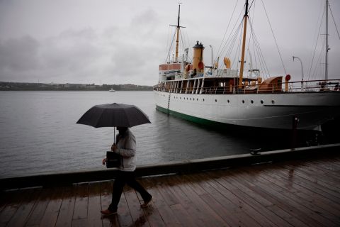 A pedestrian protects themselves with an umbrella as they walk along the Halifax waterfront on Friday.