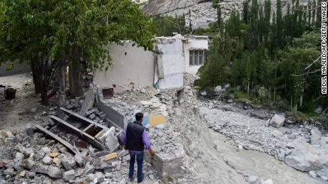 A local resident stands next to his destroyed home in June after a glacial lake explosion caused catastrophic flooding in the village of Hassanabad in northern Pakistan. 
