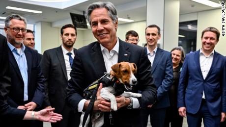US Secretary of State, Anthony Blinken, holds Patron, a dog that sniffs out landmines, while visiting a children's hospital in Kyiv.