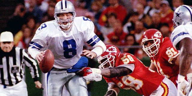 Dallas Cowboys quarterback Troy Aikman is about to be sacked by Kansas City Chiefs quarterback Derek Thomas (right) in Kansas City.