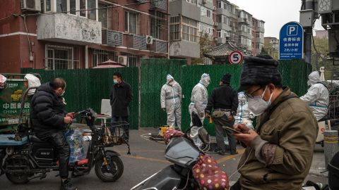 Covid workers wearing Hazmat outfits help delivery drivers drop off goods for residents under lockdown in Beijing on November 24.