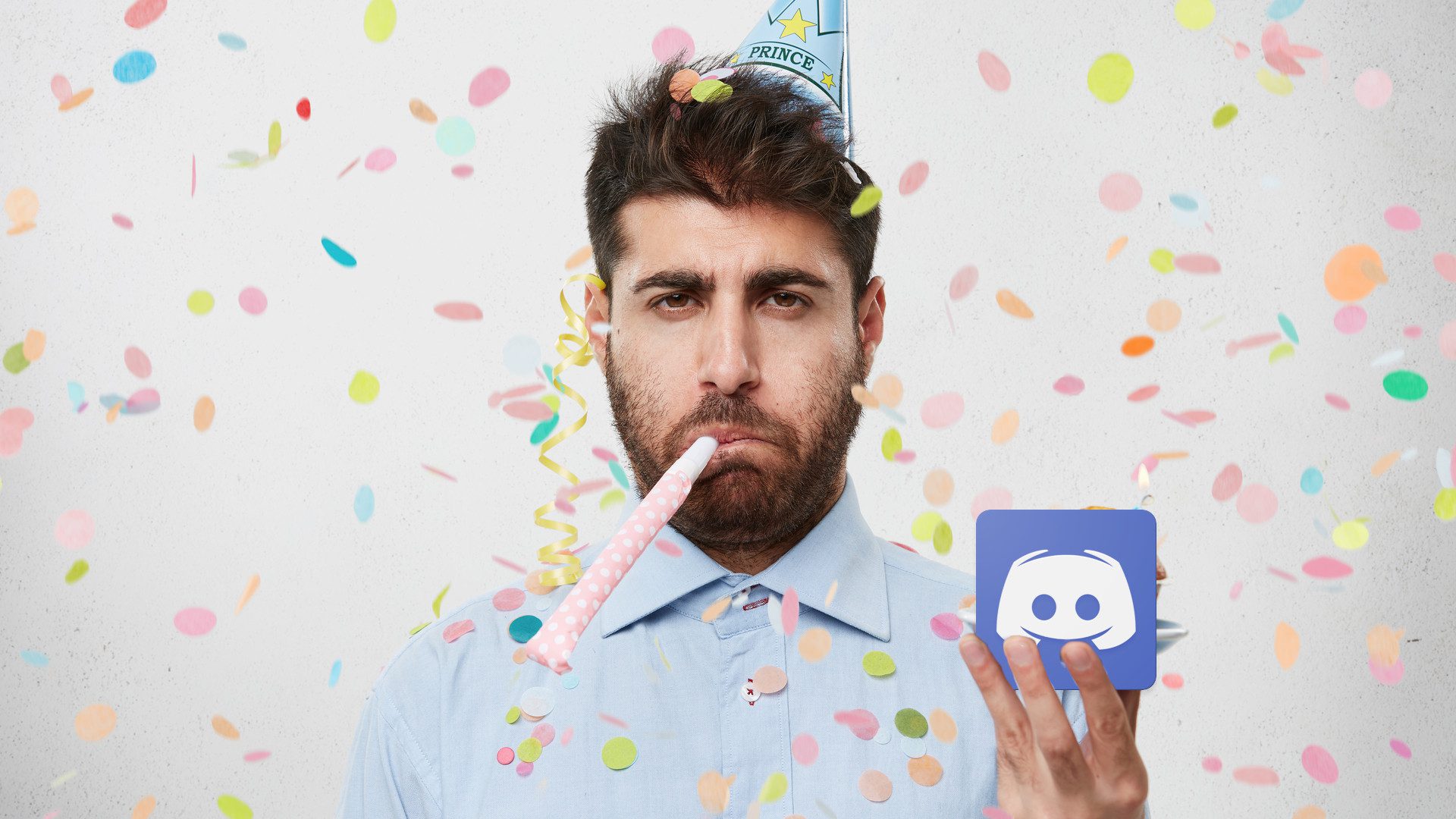 A man looking unhappy at a party holding the Discord app logo