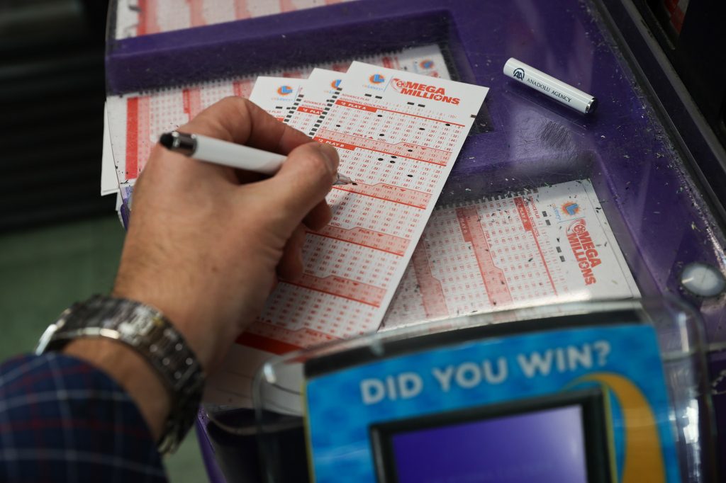 A person plays the Mega Millions lottery at a convenience store in San Mateo, California.