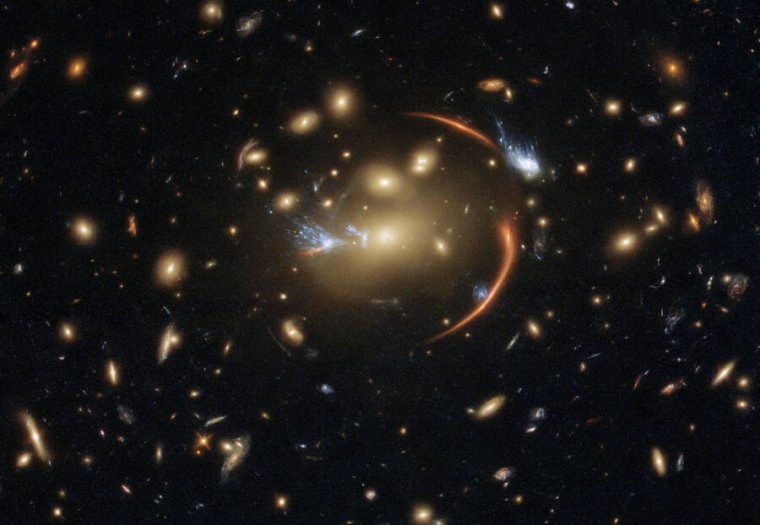 Image of many galaxies, with some distorted lines near the center.