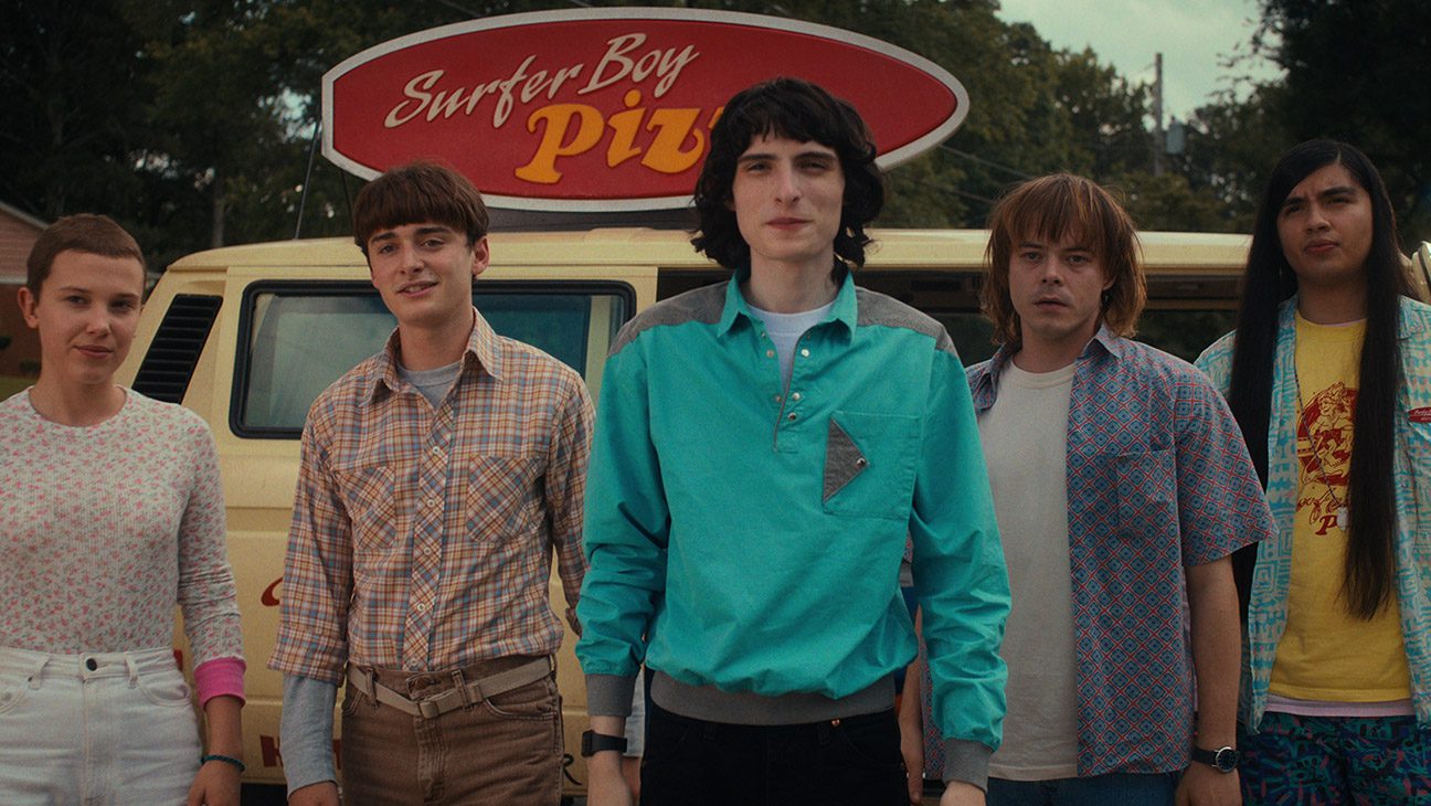 (L to R) Millie Bobby Brown as Eleven, Noah Schnapp as Will Byers, Finn Wolfhard as Mike Wheeler, Charlie Heaton as Jonathan Byers, and Eduardo Franco as Argyle in Stranger Things.