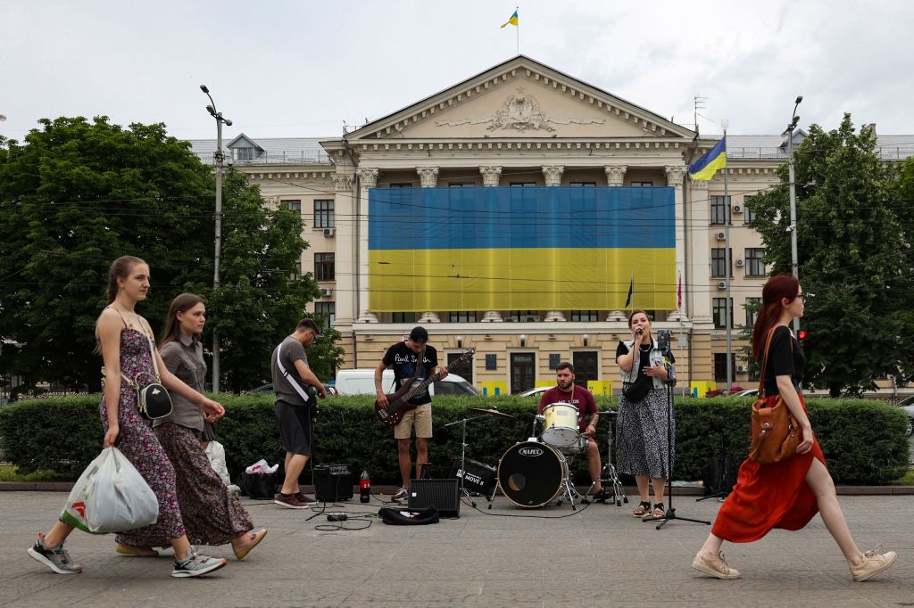 Residents of Zaporizhzhia are pictured walking past a band playing music on June 10, 2023.