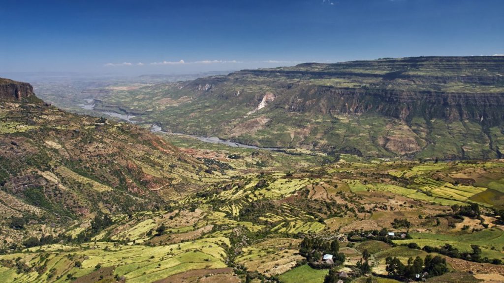 An overhead view of the East African Rift, with a river in a cultivated valley flanked by steep cliffs