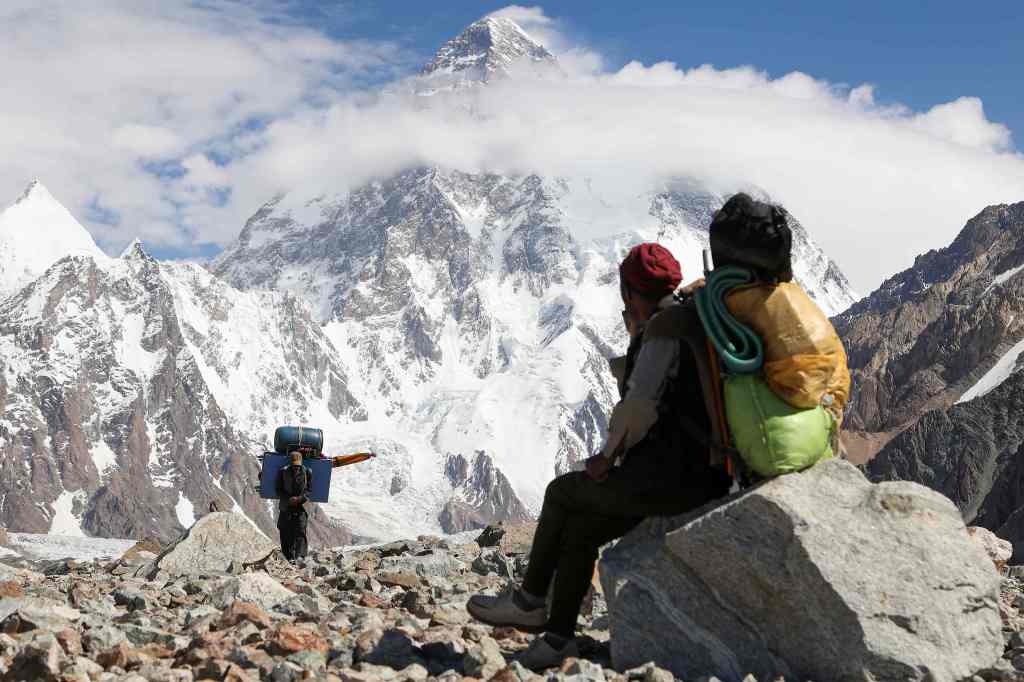 This photo taken on July 15, 2023 shows a Pakistani porter looking towards K2, the second highest mountain in the world in the Karakoram mountain range.