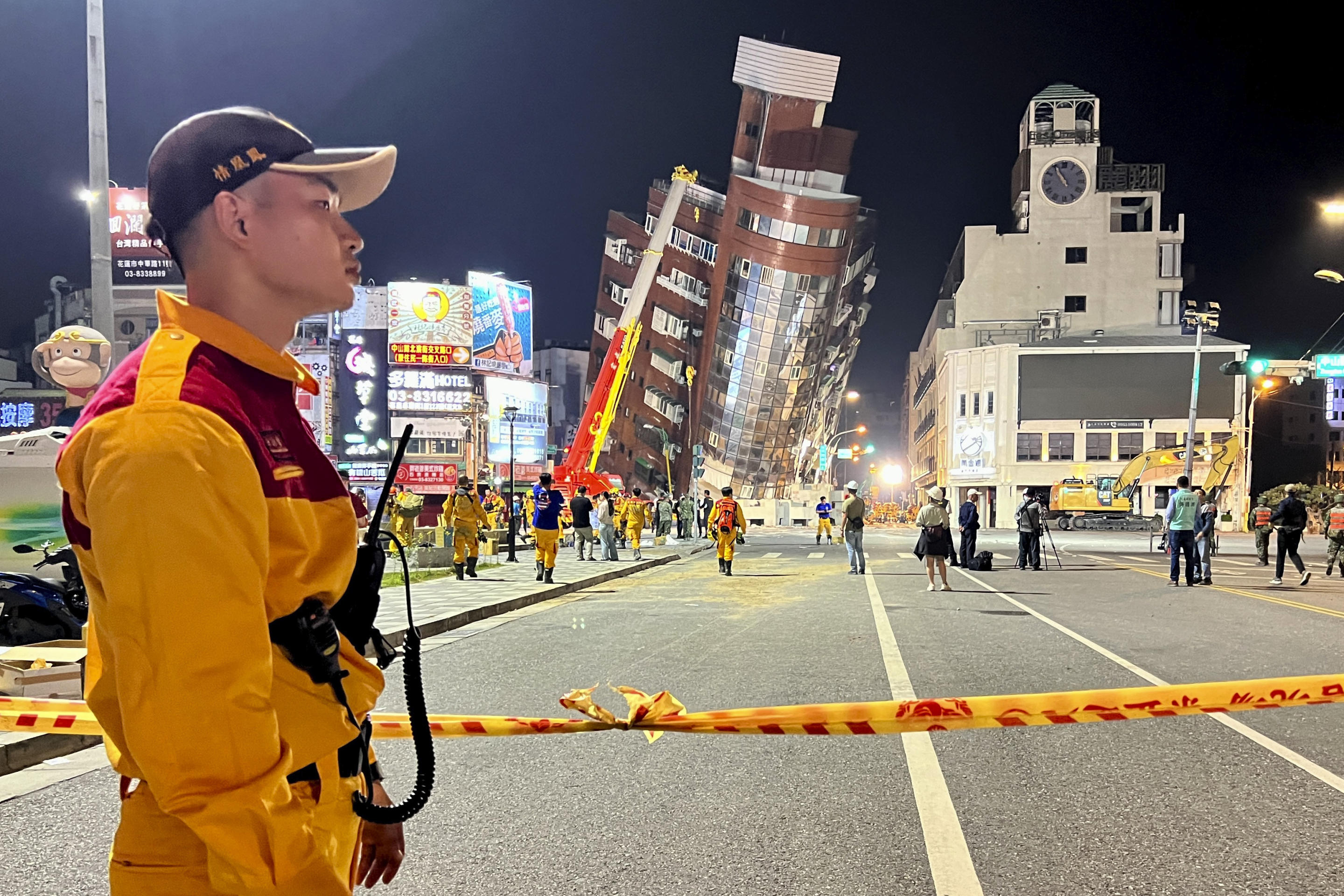 A rescue worker stands near the cordoned off site of a leaning building following the earthquake that struck Hualien City.